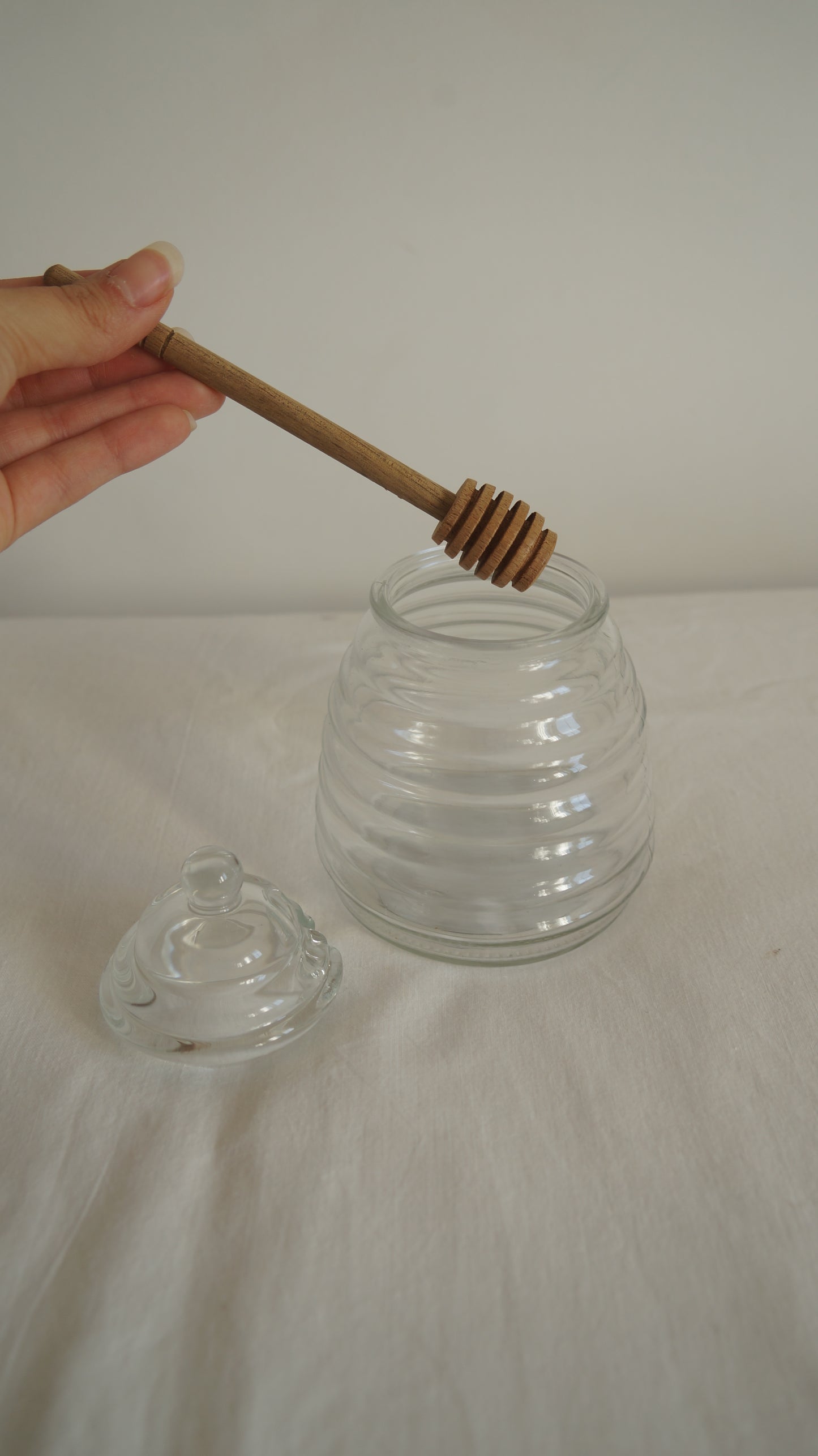 Tarro de vidrio para la miel con palo mielero